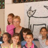 La mosaïque en place dans la cour de l'école avec l'enseignante et les élèves.